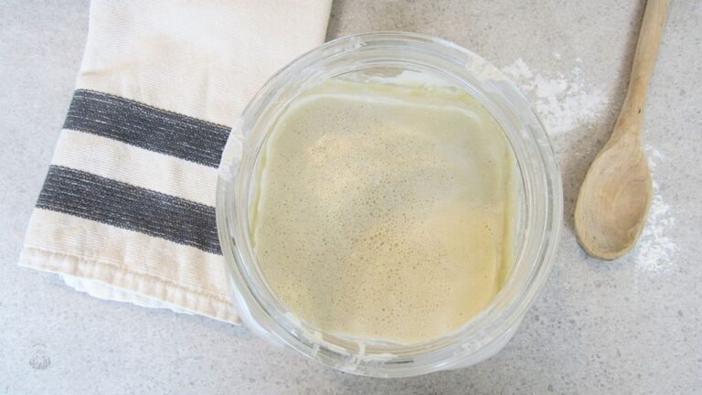 łatwy zakwas na wypieki w słoju i łyżka drewniana na blacie