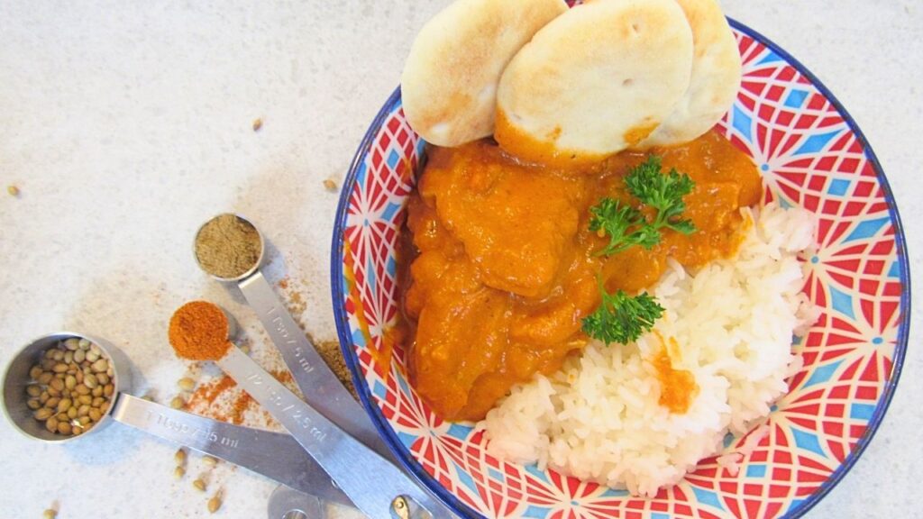 miska z ryżem i prosta indyjska potrawka z kurczaka oraz łyżeczki z przyprawy