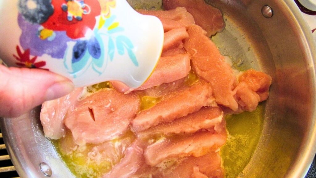 kawałki kurczaka na patelni i solniczka