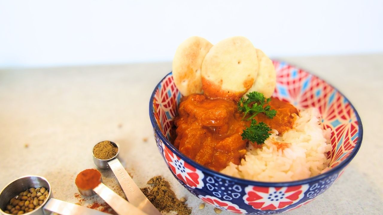 Prosta indyjska potrawka z kurczaka w misce z ryżem i mini naan