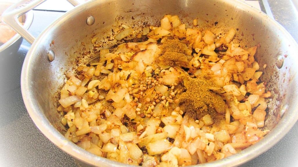 pokrojona cebulka, czosnek, imbir i przyprawy - prosta indyjska potrawka z kurczaka