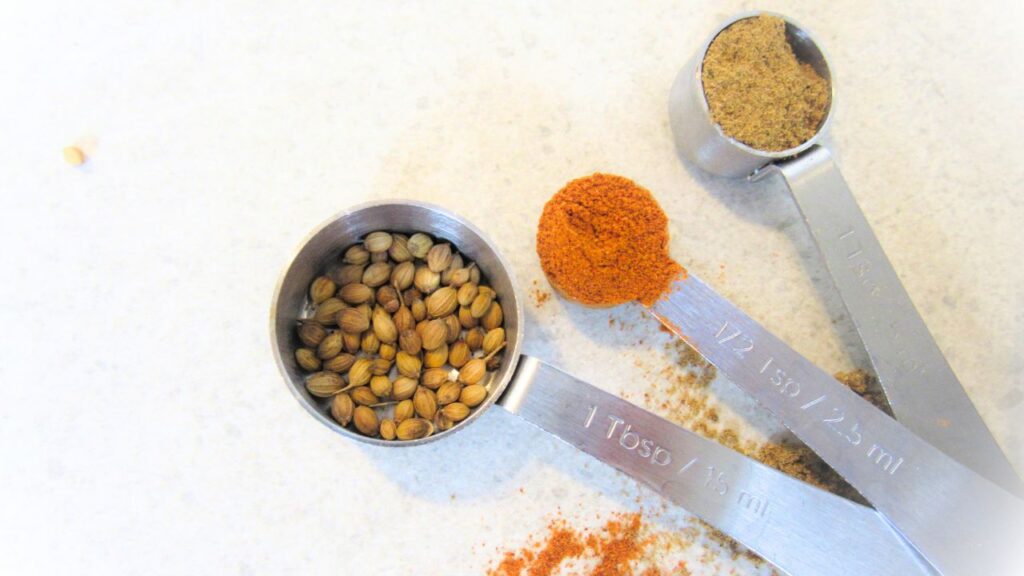 łyżeczki z przyprawami garam masala, chilli i kolendra