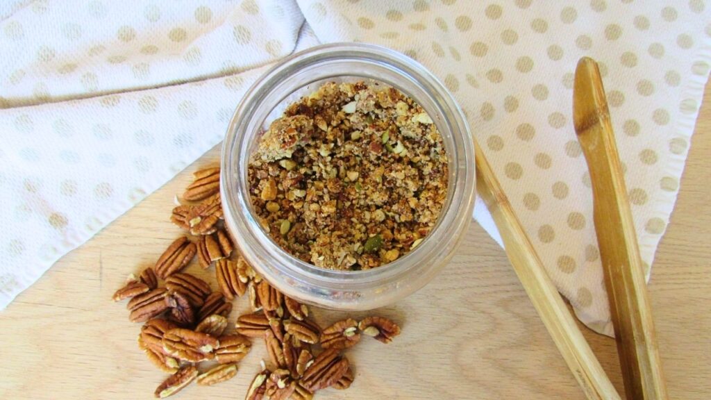 zdrowa granola w słoik z rozsypanymi orzechami