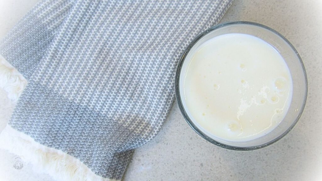 kefir w szklance obok ręcznika kuchennego