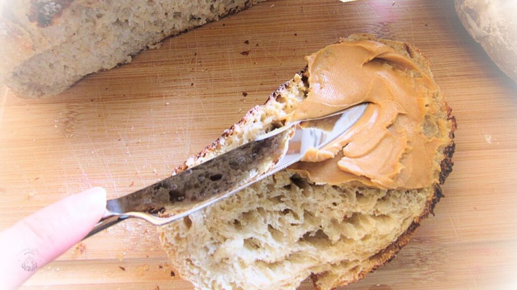 kromka tradycyjnego chleba na zakwasie smarowana masłem orzechowym