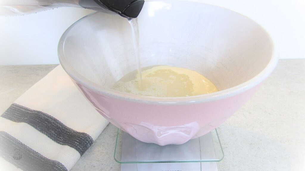 woda wlewana do zakwasu w misce nan tradycyjny chleb na zakwasie