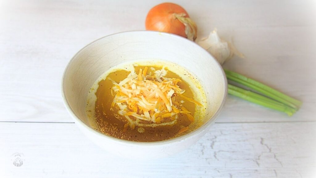 miska, w której jest przepyszna zupa krem z selera, posypana startym serem