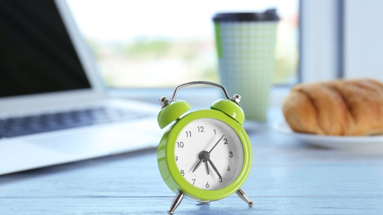 budzik a w tle komputer i kawa