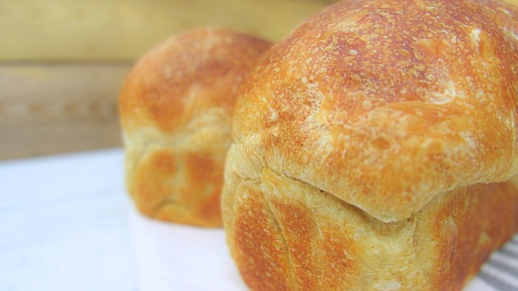 puszysty chleb tostowy na zakwasie a w tle drugi bochenek