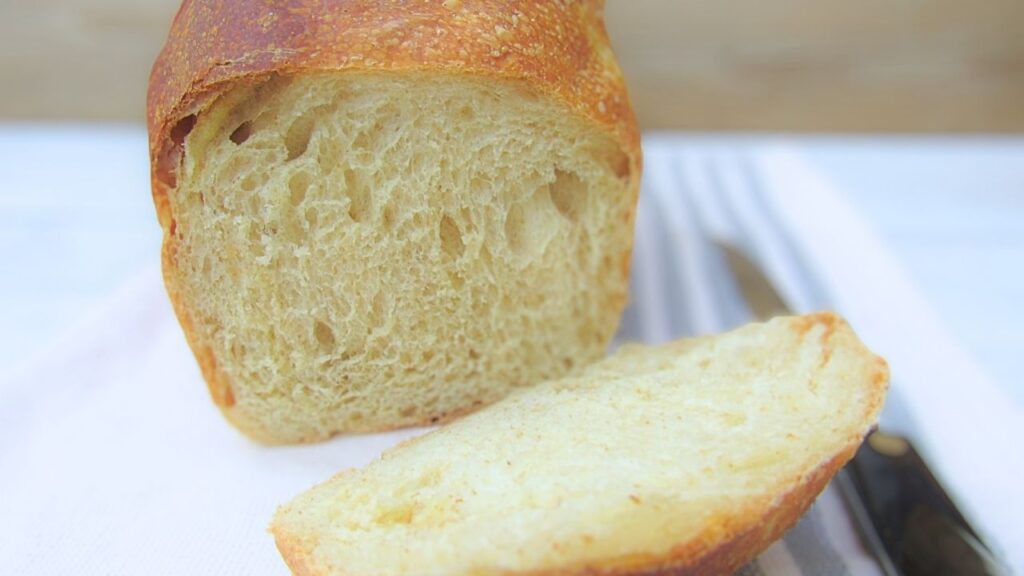 puszysty chleb tostowy na zakwasie na ścierce z nożem obok