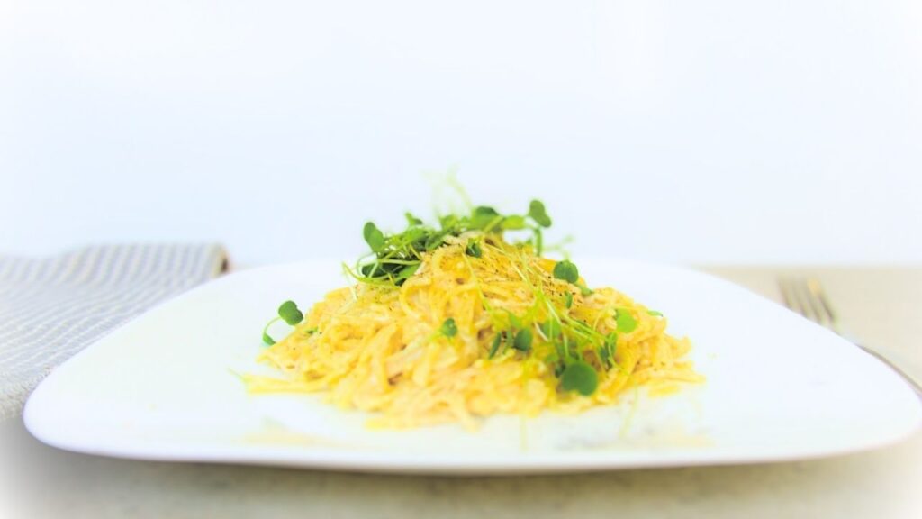 gotowy łatwy makaron z kurczakiem w sosie alfredo na talerzu na blacie kuchennym