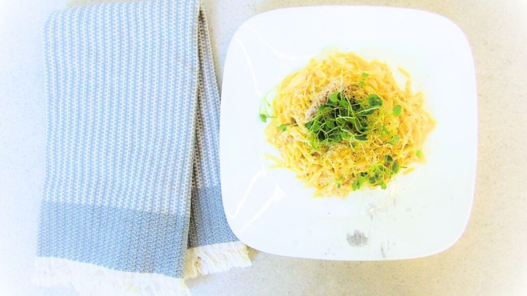 łatwy makaron z kurczakiem w sosie alfredo a obok ręczniczek kuchenny