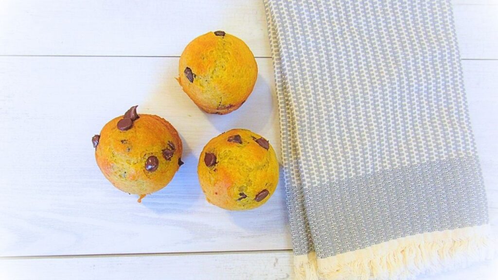 puszyste muffiny z czekoladą i malinami na zakwasie za ściereczką w tle