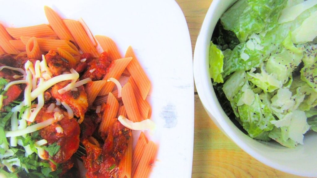 szybki makaron z bekonem na talerzu i sałatka cesarka