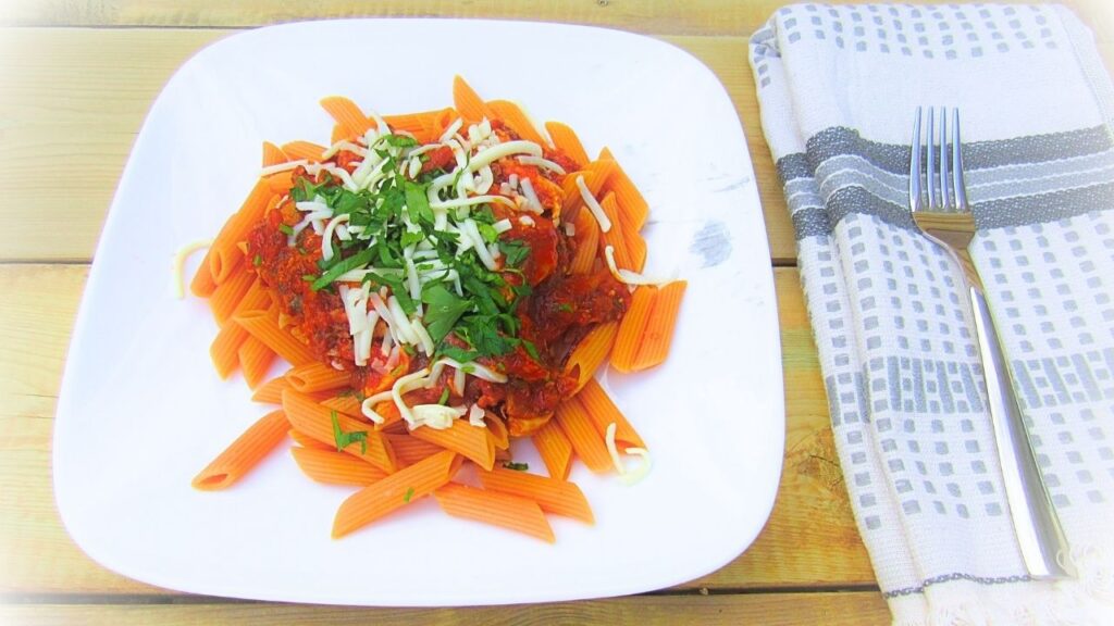 szybki makaron z bekonem na talerzu a obok widelec na ręczniczku kuchennym