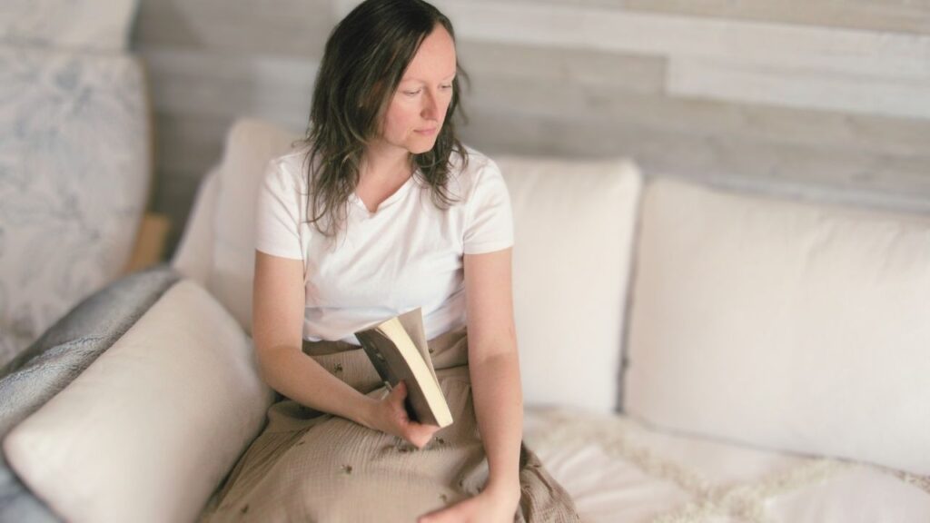 dziewczyna na białej sofie z książką w spódnicy z Neuflora