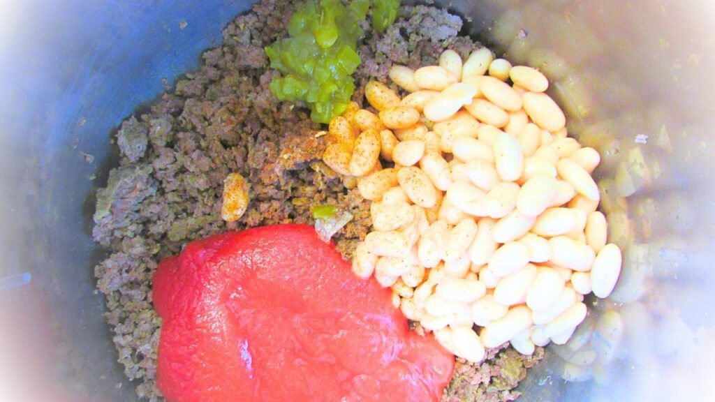 mięso mielone, fasola, sos pomidorowy i trochę papryczek chilli z puszki w garnku