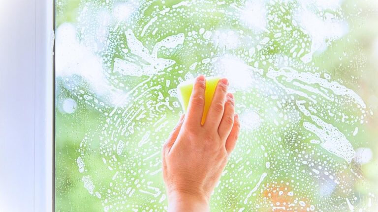 ręka myje okno