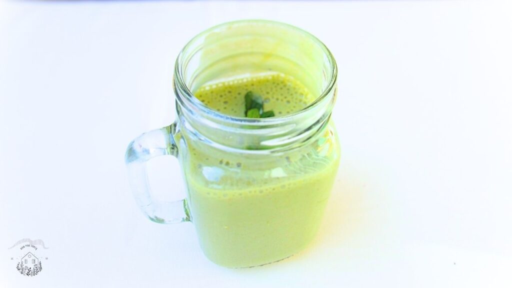 owocowy koktajl ze szpinakiem w szklance z uchem przyozdobiony liściem mięty