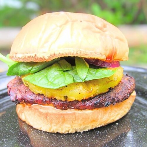 burger wołowy po hawajsku z ananasem na czarnym talerzu metalowym