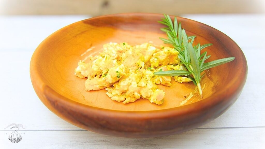 jajecznica z rozmarynem w drewnianej misce z rozmarynem świeżym na boku