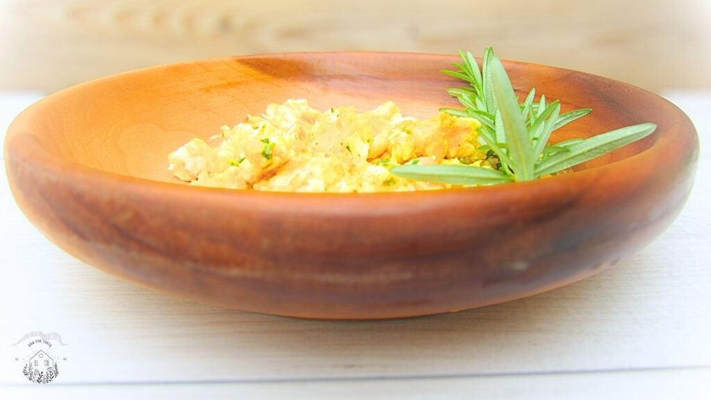 jajecznica z rozmarynem w drewnianej misce z rozmarynem świeżym na boku