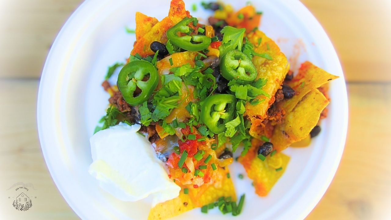 meksykańskie nachos z dodatkami na białym talerzu