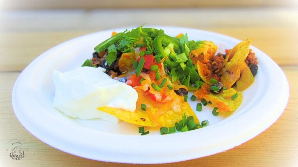 meksykańskie nachos z dodatkami na białym talerzu